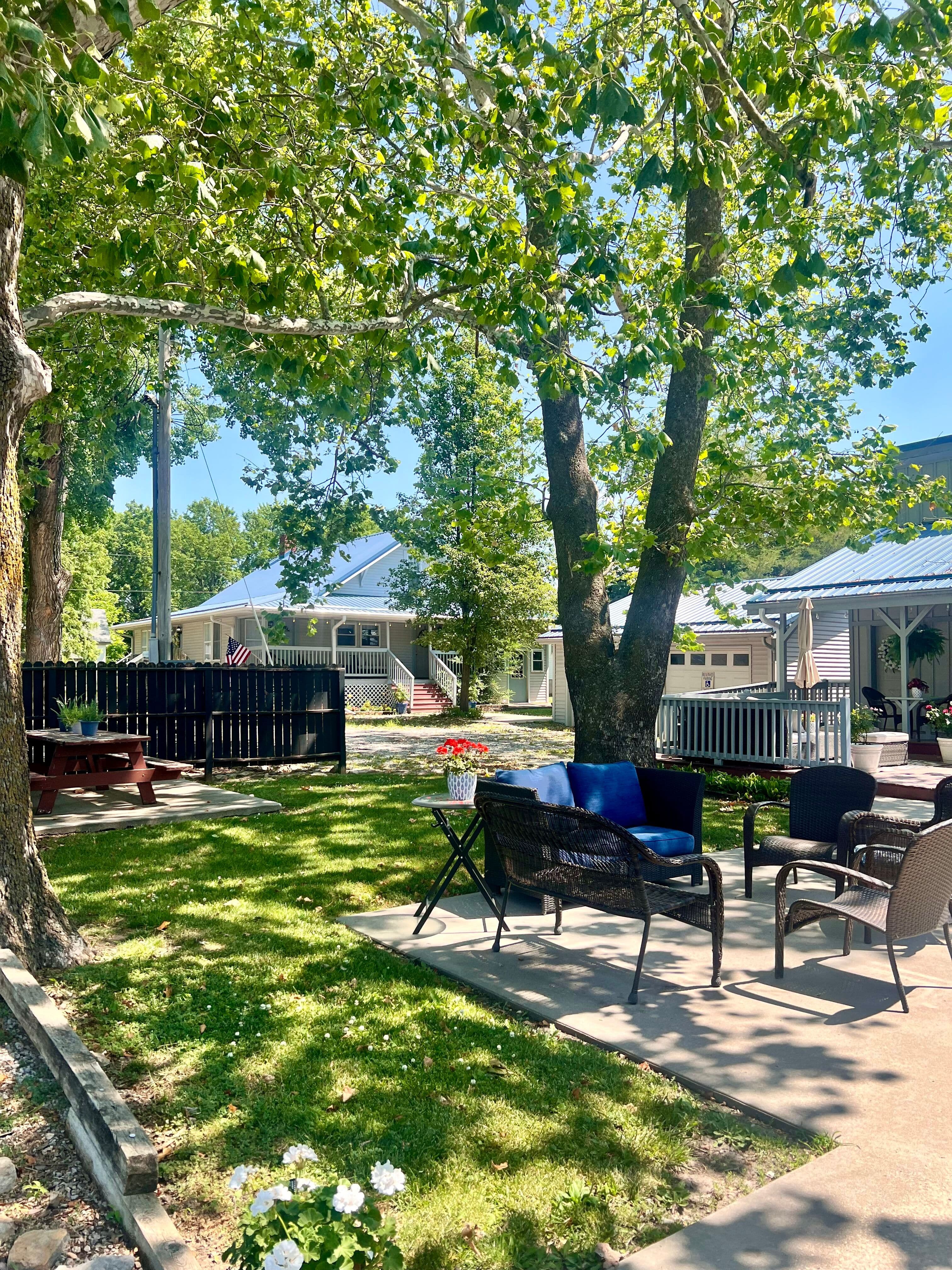 Outdoor setting area next to fire pit and mature trees
