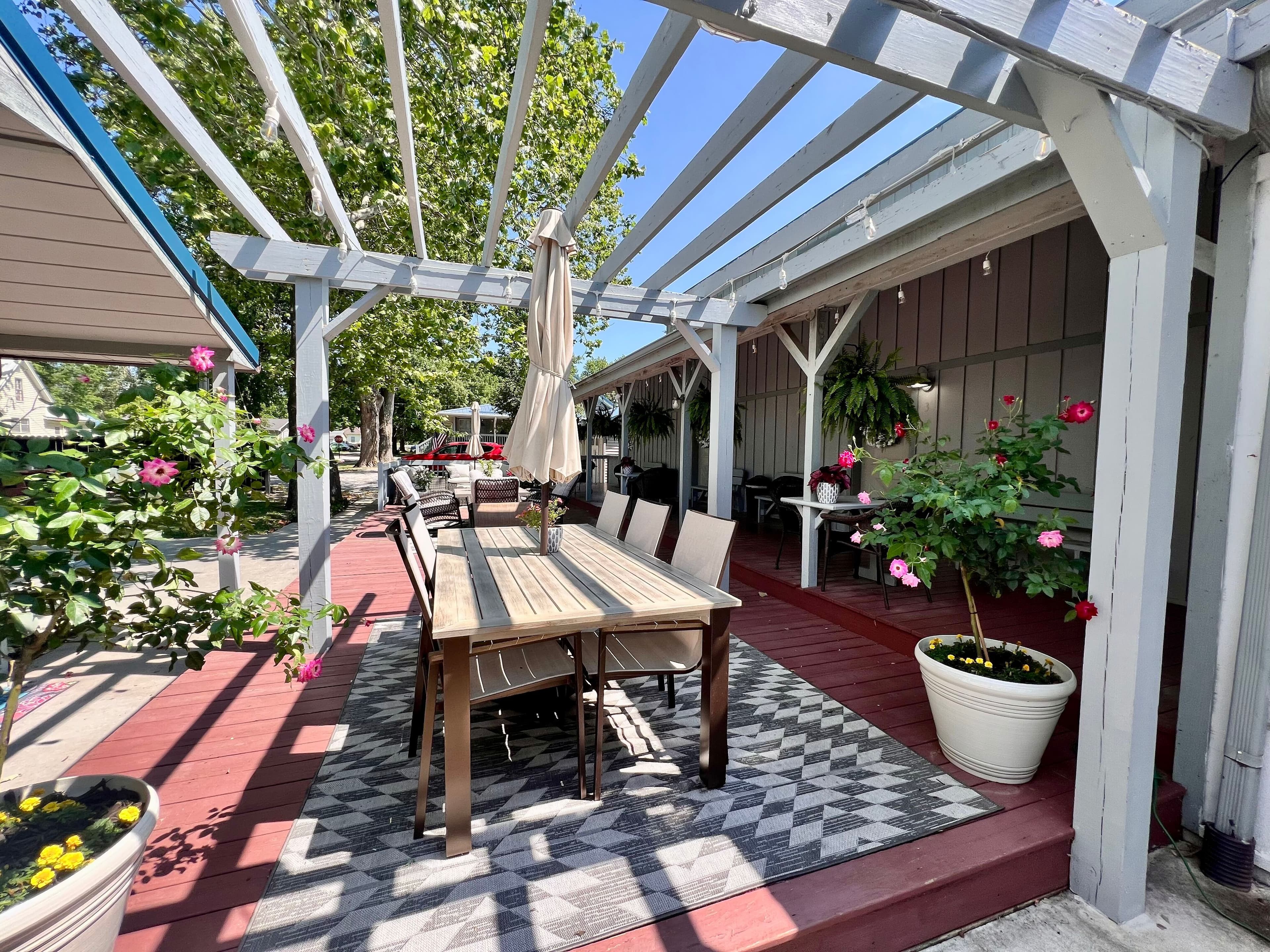 Paved patio area with seating, grass, and trees