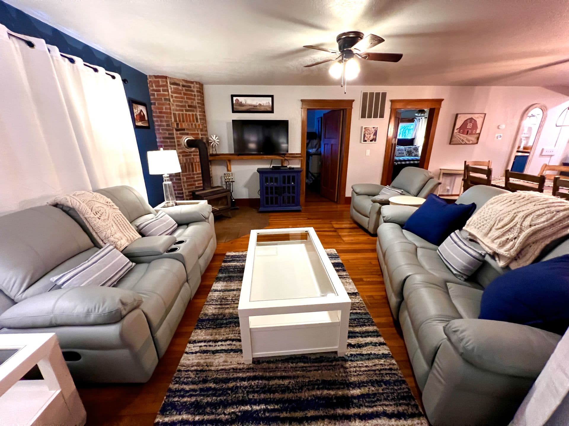 Cozy living room featuring light gray sofas, a striped rug, and a white coffee table.